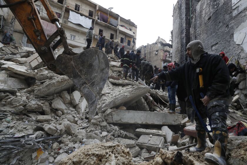 Trabajadores de protección civil y fuerzas de seguridad de Siria buscan entre los escombros de un edificio que se desplomó, el lunes 6 de febrero de 2023, en Alepo, Siria. (AP Foto/Omar Sanadiki)