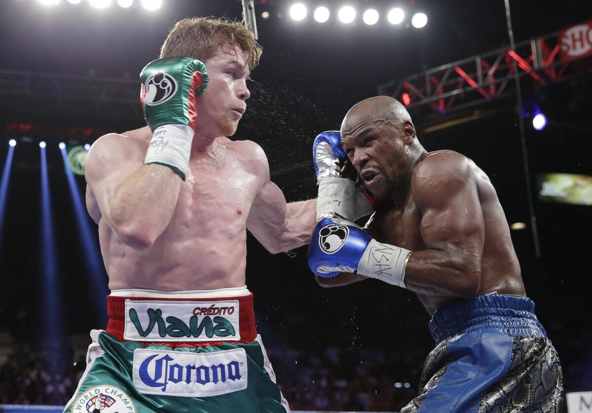 Canelo Alvarez lands a jab against Floyd Mayweather Jr. in the third round during a 152-pound title fight, Saturday, Sept. 14, 2013, in Las Vegas.