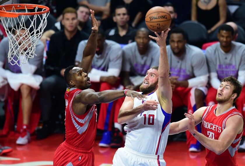 Spencer Hawes puts up a shot against Houston forward Joey Dorsey during the first half of a game Wednesday at Staples Center.