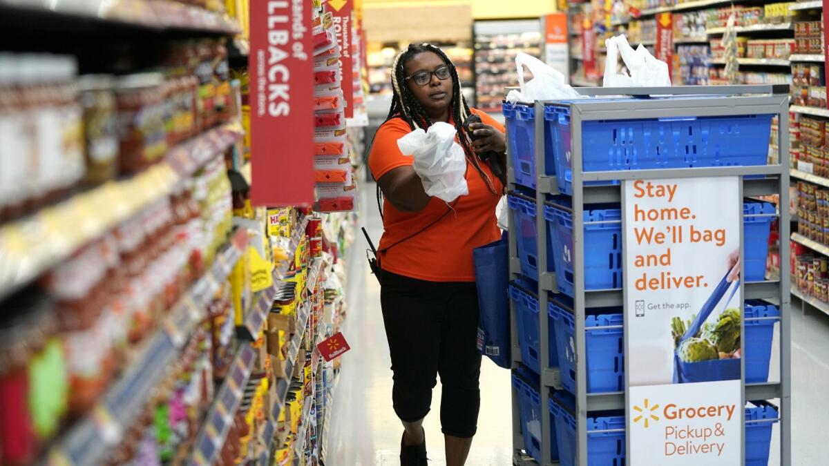Walmart associate Alicia Carter fulfills online grocery orders in Houston. Walmart is training 7,000 workers a week.