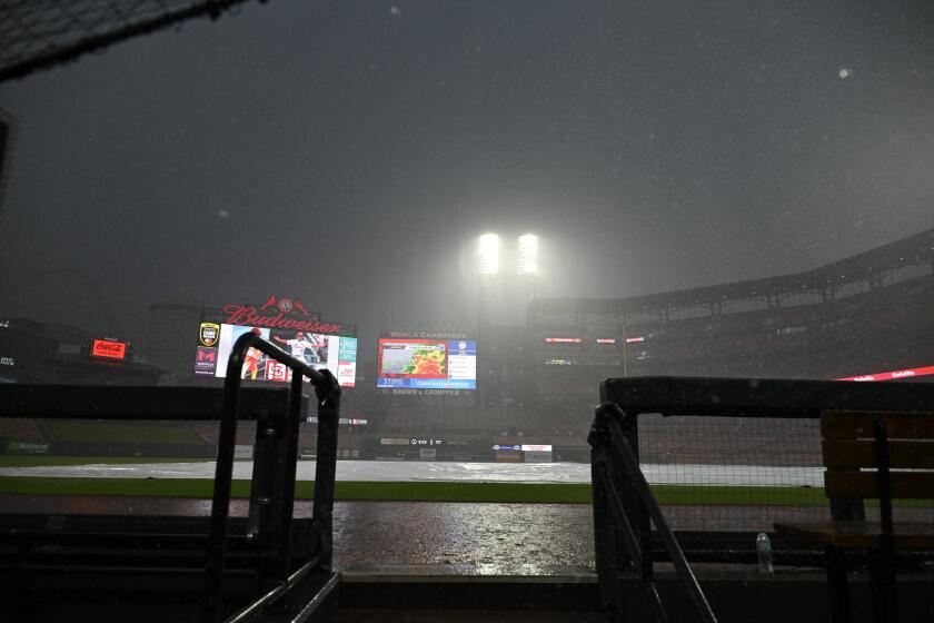 A tarp covers the field as rain falls during a rain delay in the 10th inning of a baseball game between the St. Louis Cardinals and the Chicago White Sox Saturday, May 4, 2024, in St. Louis. (AP Photo/Jeff Le)