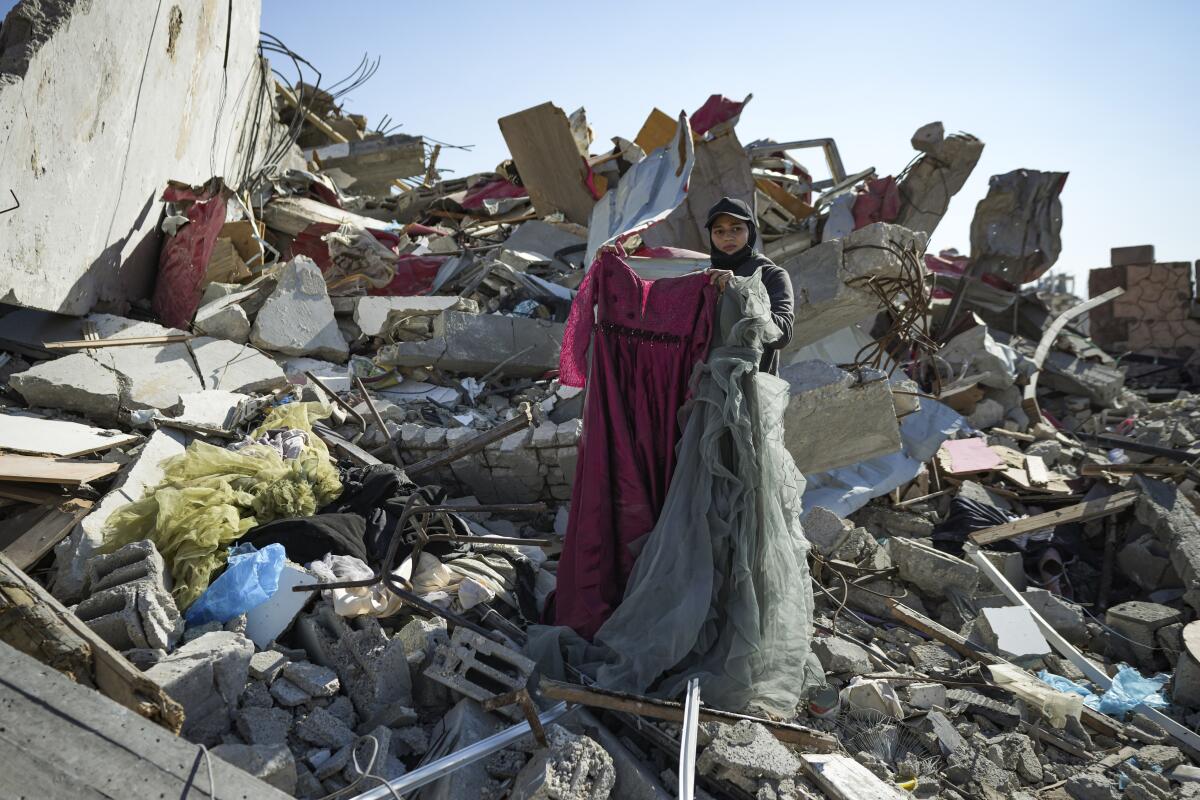 A woman searches through the rubble of her home.