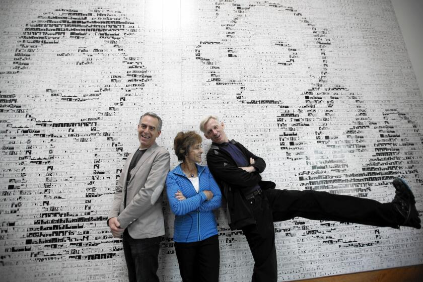 Cartoonist Charles Schulz's son Craig, right, clowns around demonstrating his kicking prowess as Schulz's widow, Jeannie, and director Steve Martino look on at a mural depicting Charlie Brown about to be fooled by Lucy again, inside the Peanuts Museum in Santa Rosa, where they talked about "The Peanuts Movie."