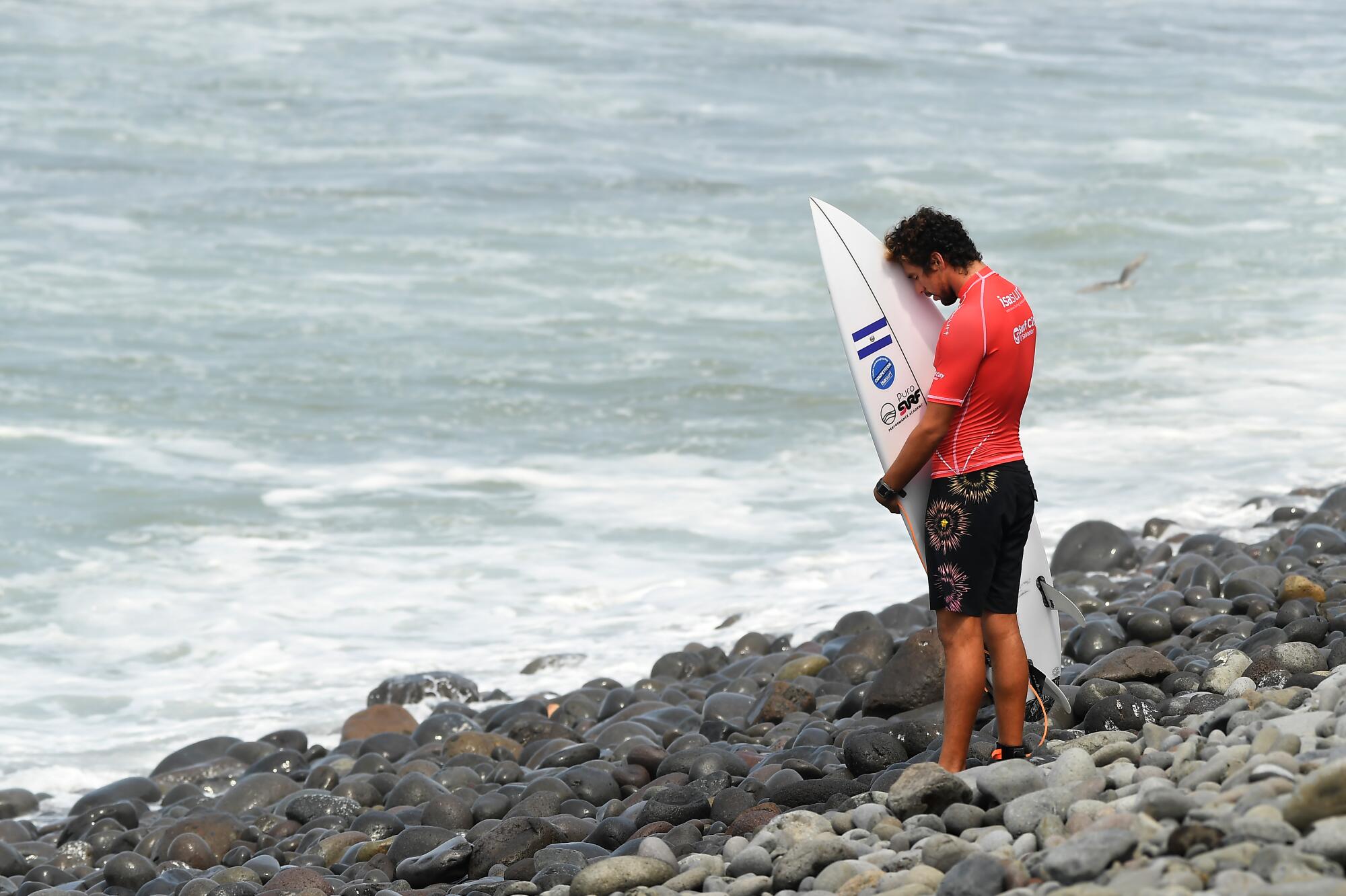 Surfer Bryan Perez prays before competing in the ISA World Surfing Games in El Salvador.