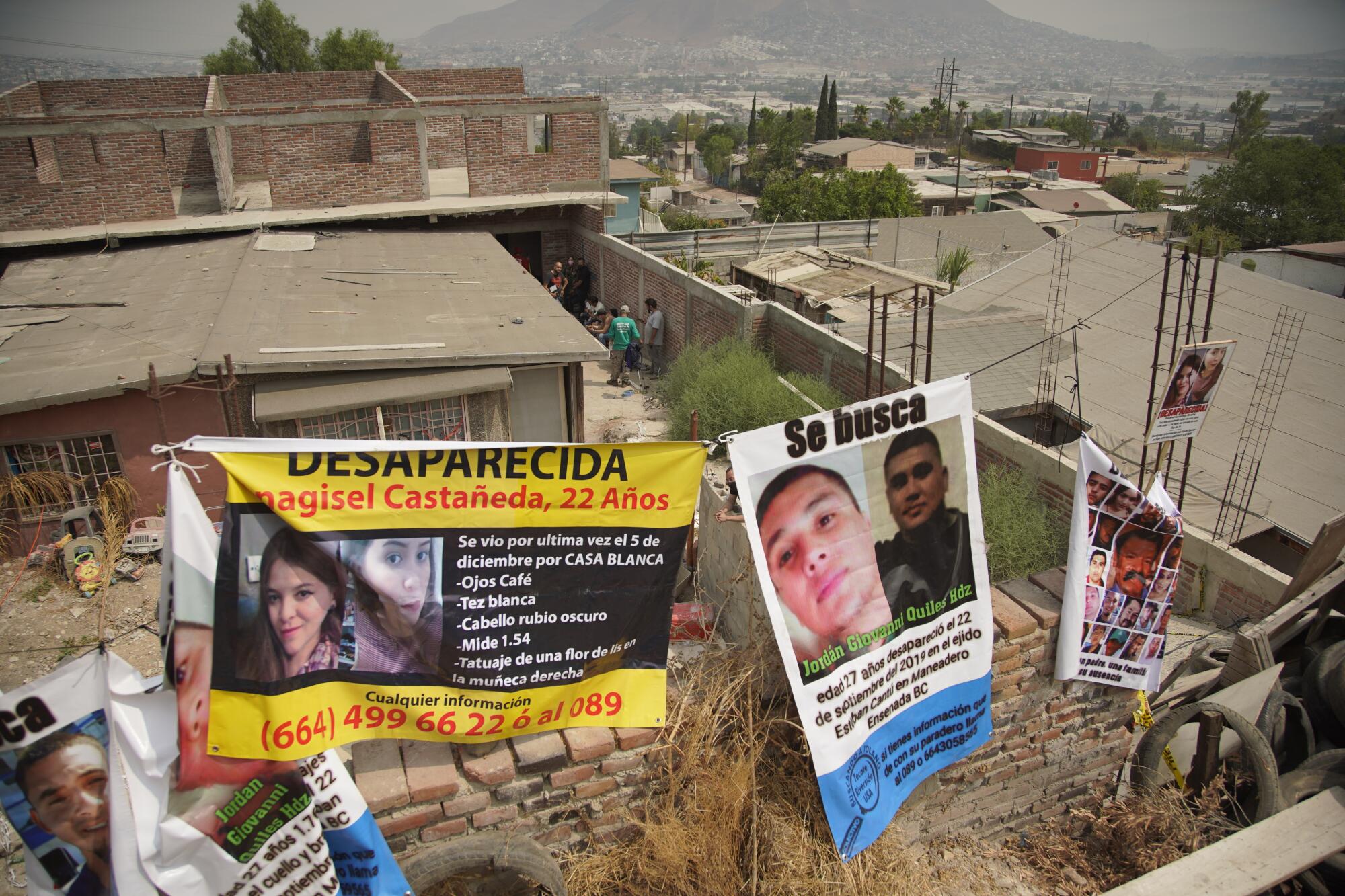 Banners on the property line of a house carry pictures and information about missing children.