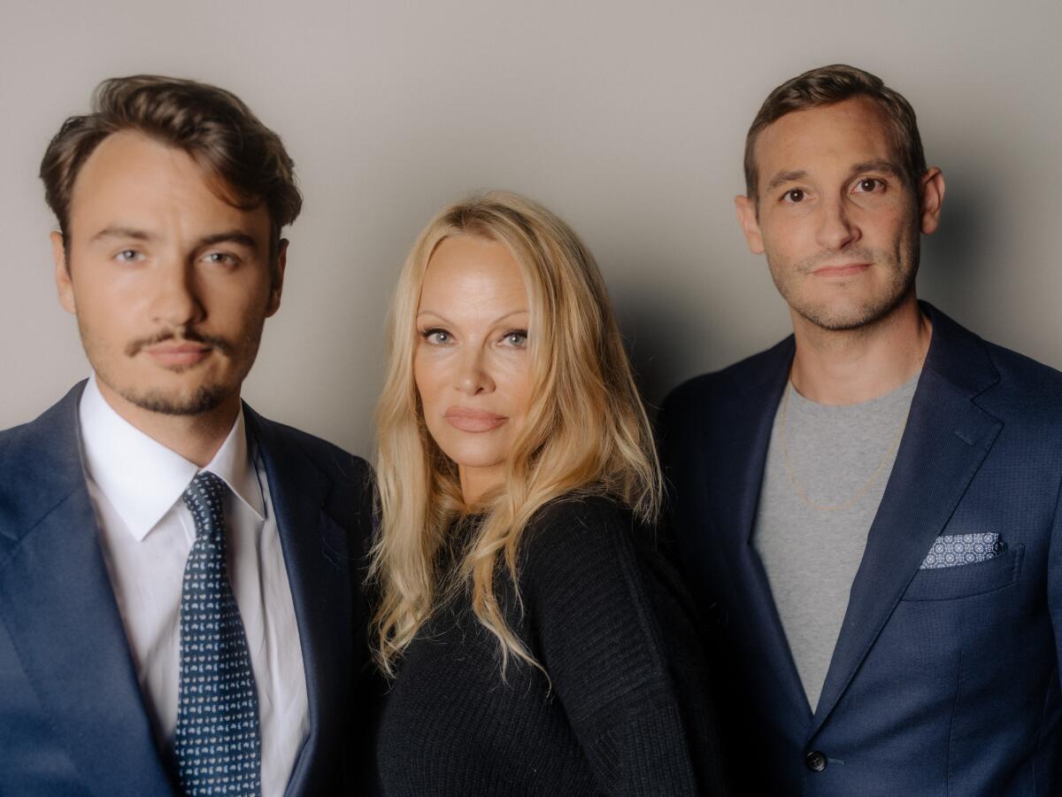 Pamela Anderson is flanked by her eldest son, Brandon Thomas Lee, and filmmaker Ryan White. 