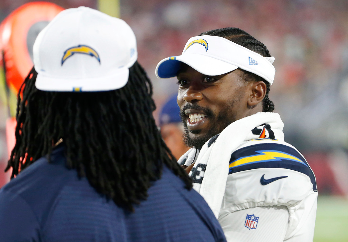 Chargers quarterback Tyrod Taylor speaks with a teammate on the sideline.