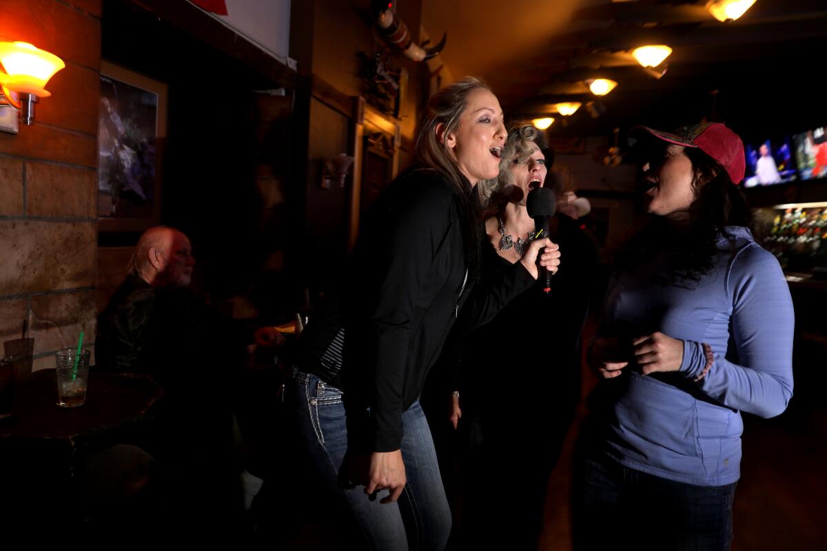 Rebecckeh Odle, left, and Natasha Keys, center, sing karaoke 