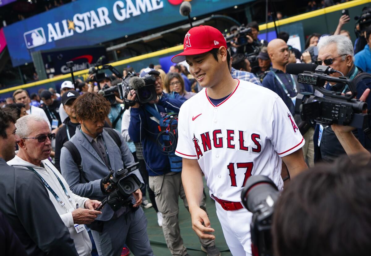 Angels star Shohei Ohtani makes his way past a throng of journalists at T-Mobile Park in Seattle.