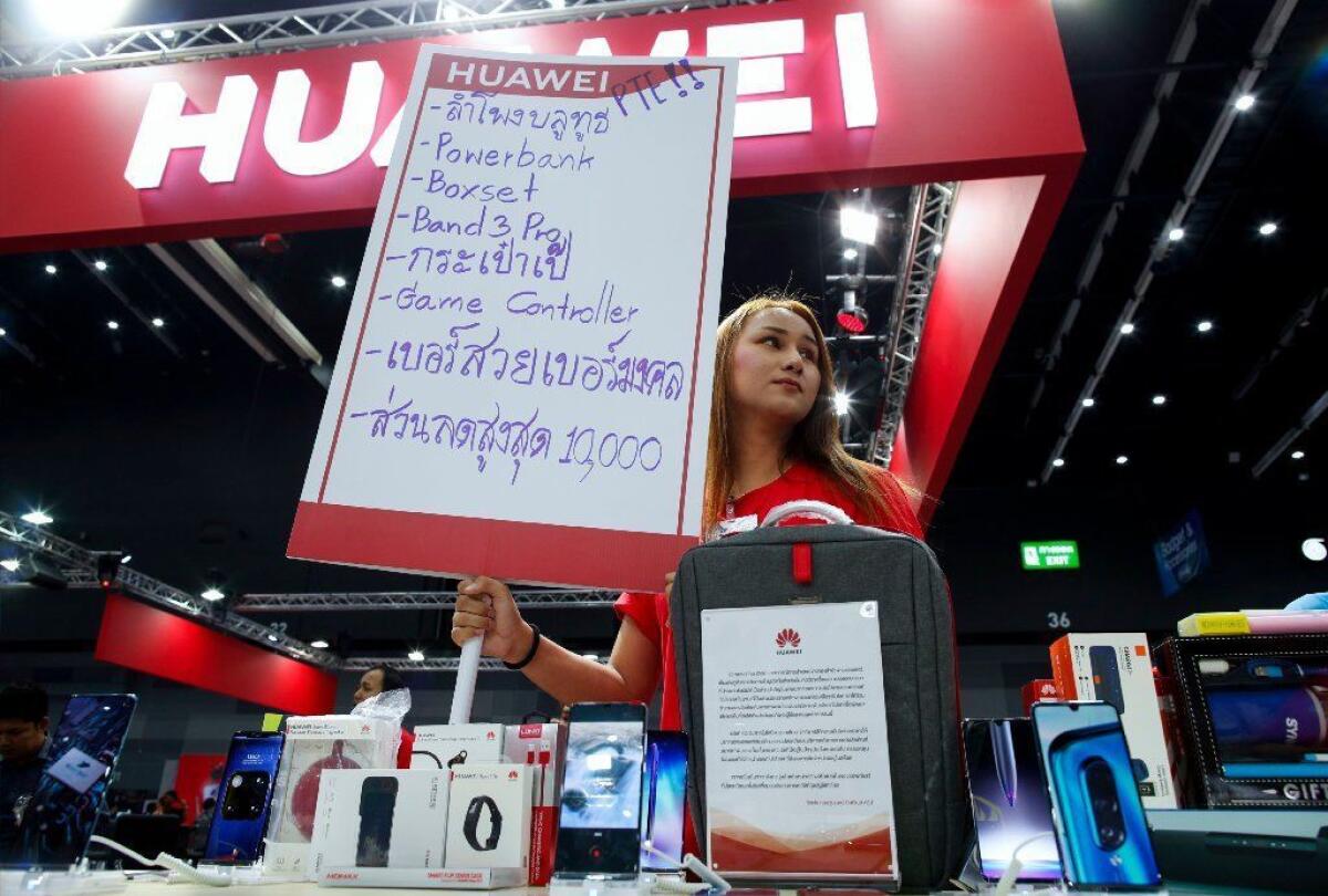 A salesperson offers discounts and promotions for Huawei smartphones at the Thailand Mobile Expo 2019 in Bangkok.