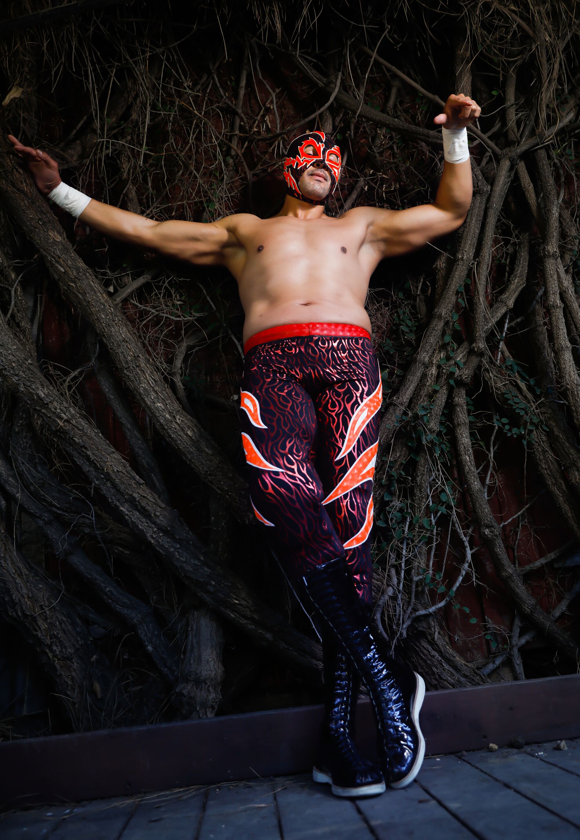 A luchador wears matching red-flame mask and tights.