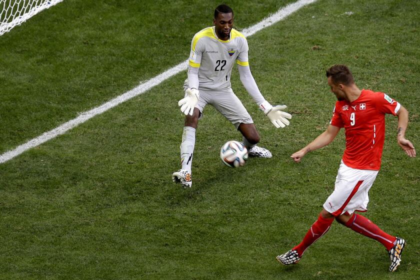 Switzerland forward Haris Seferovic sends a shot past Ecuador goalkeeper Alexander Dominguez in stoppage time to clinch a 2-1 victory in a World Cup Group E game Sunday at the Estadio Nacional in Brasilia, Brazil.