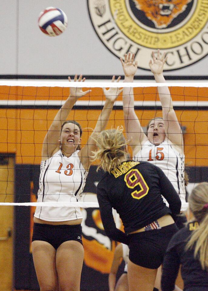 South Pasadena's Hailey Leach, left, and Sohpia Hathaway, right, try to block a spike from La Canada's Lauren Streeter during a game at South Pasadena High School on Thursday, September 27, 2012.