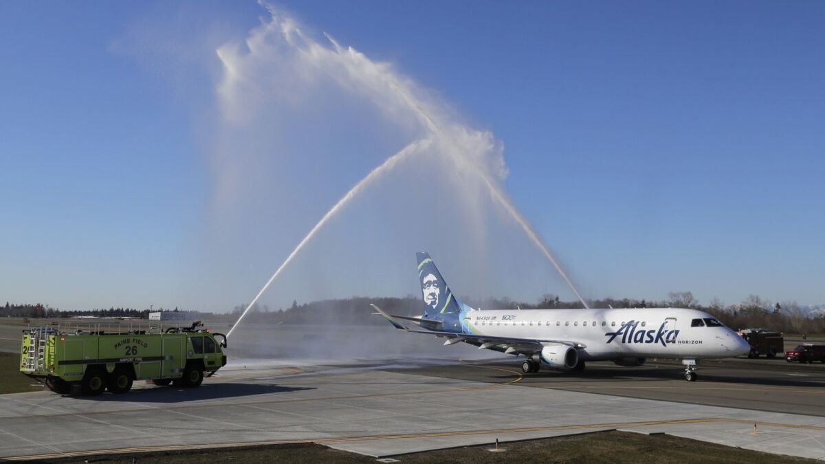 An Alaska Airlines Embraer 175 airplane gets a water-arch departure on Monday as it taxis for take-off for a flight to Portland, Ore., at Paine Field in Everett, Wash. The flight was the first flight on the inaugural day of commercial passenger service from the airport.