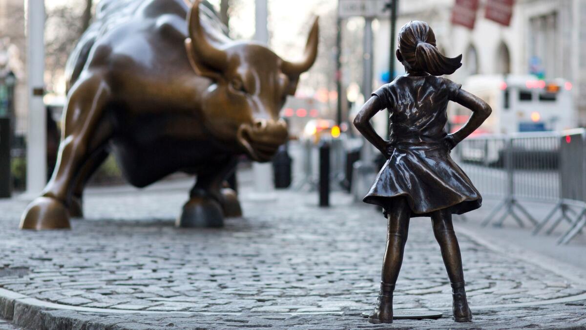 "Fearless Girl" stands in front of "Charging Bull" in New York's Wall Street district. (Mark Lennihan / Associated Press)