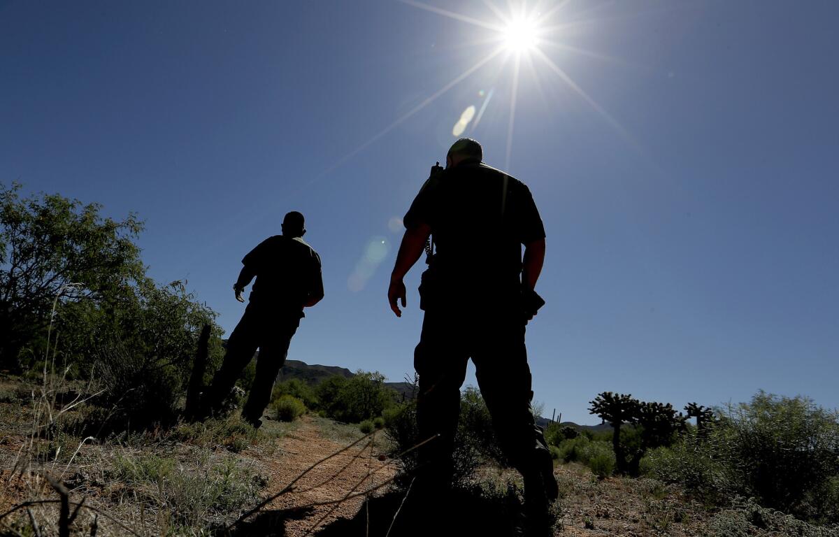 Border Patrol agents look for surveyors markers that show the future location of a surveillance tower in the sprawling Tohono O'odham Nation. (Luis Sinco / Los Angeles Times)