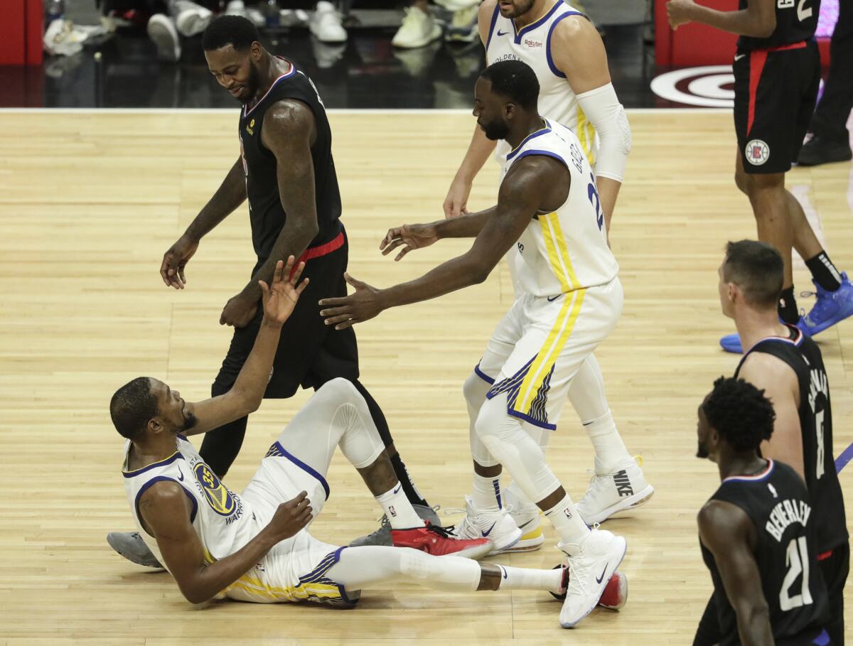 Clippers' JaMychal Green talks to Golden State Warriors' Kevin Durant after knocking him to the court for a third quarter offensive foul on the Clippers in Game 3 of the first round of the NBA playoffs at Staples Center on Thursday.