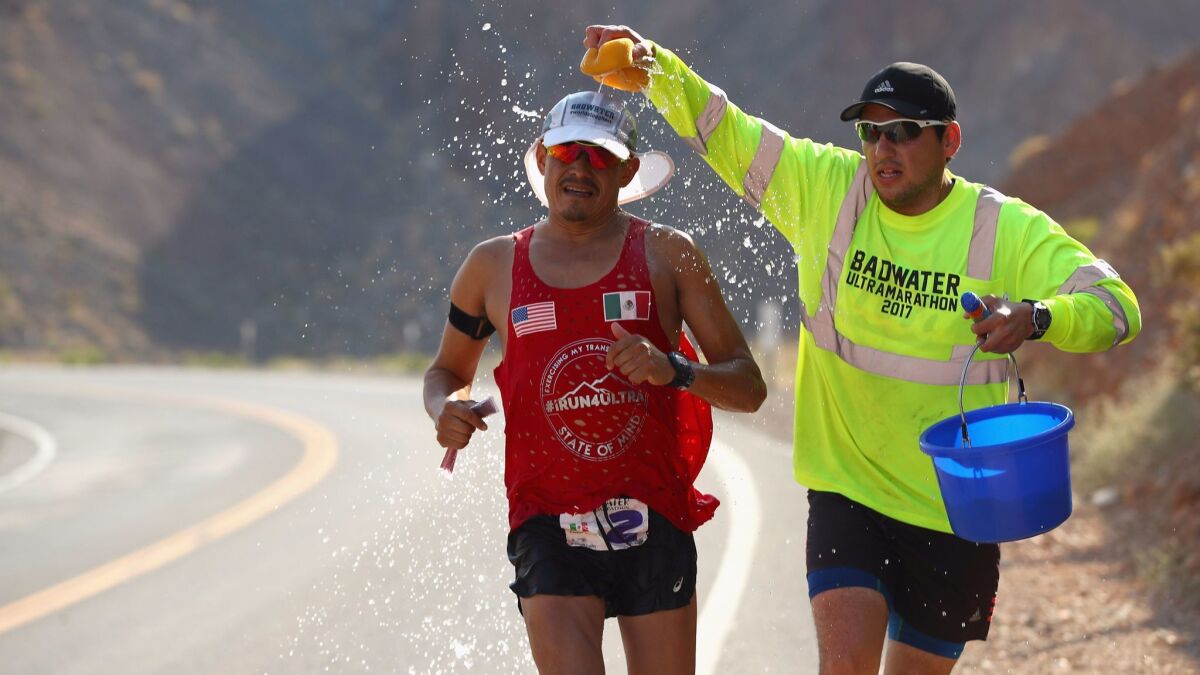 Oswaldo Lopez, 45, is sponged with water by a member of his support team, Ulises Sanchez. Lopez was expected to be a top finisher but pulled out of the race after more than 15 hours, felled by stomach pain.