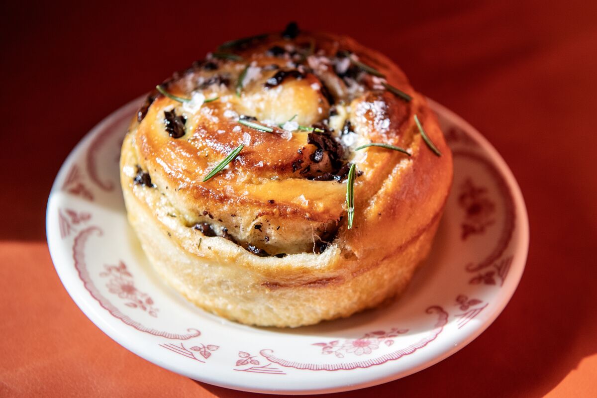 A round focaccia with salt and herbs sprinkled on top