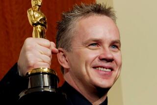 Actor Tim Robbins poses with his Oscar for Best Actor In A Supporting Role during ton February 29, 2004