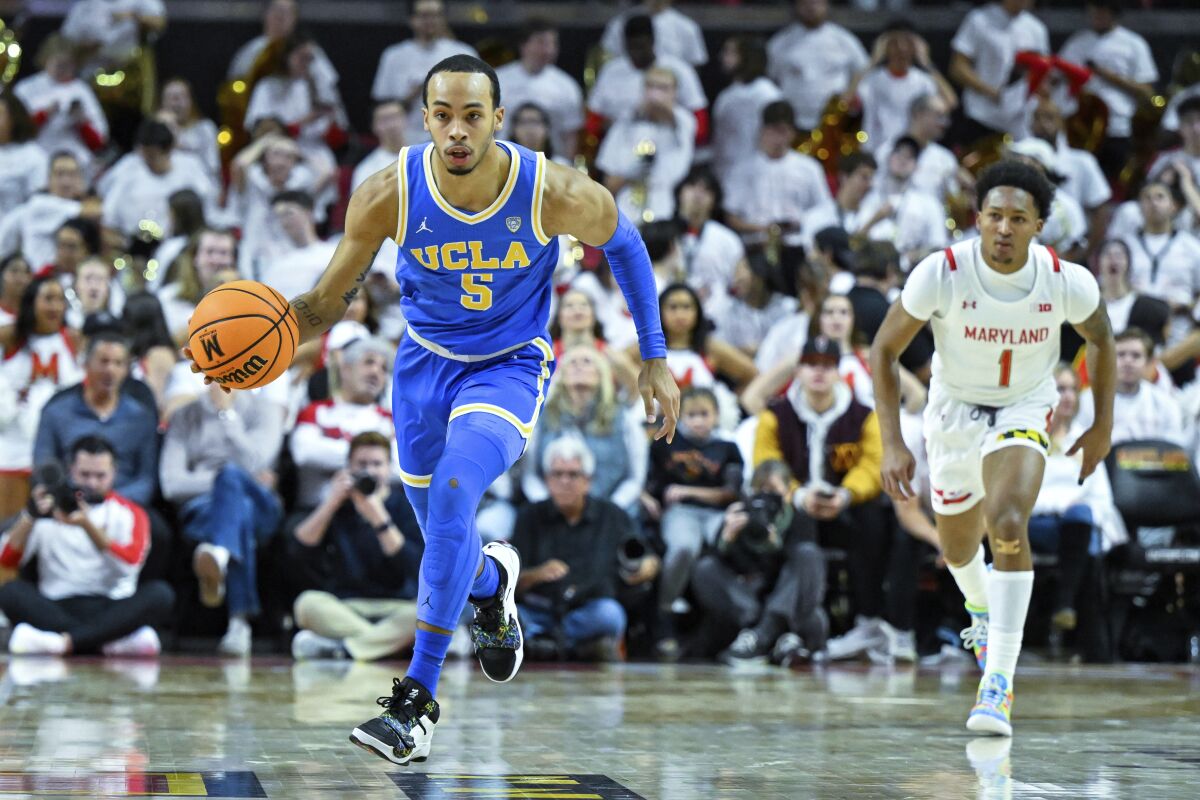 UCLA guard Amari Bailey brings the ball up court as Maryland guard Jahmir Young trails.