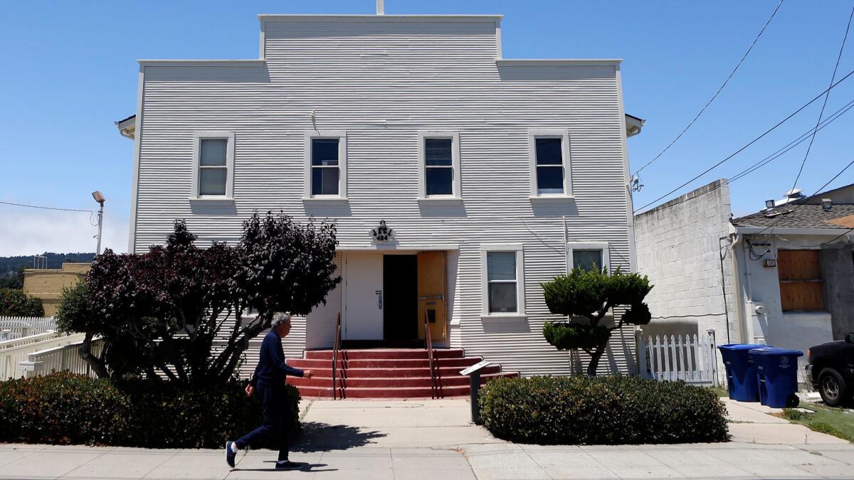 A man walks past the Japanese American Citizens League Hall in Monterey.
