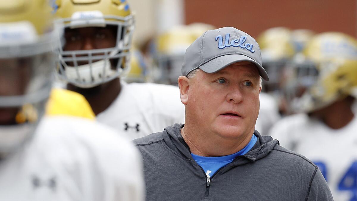 UCLA coach Chip Kelly leads his players onto the field.