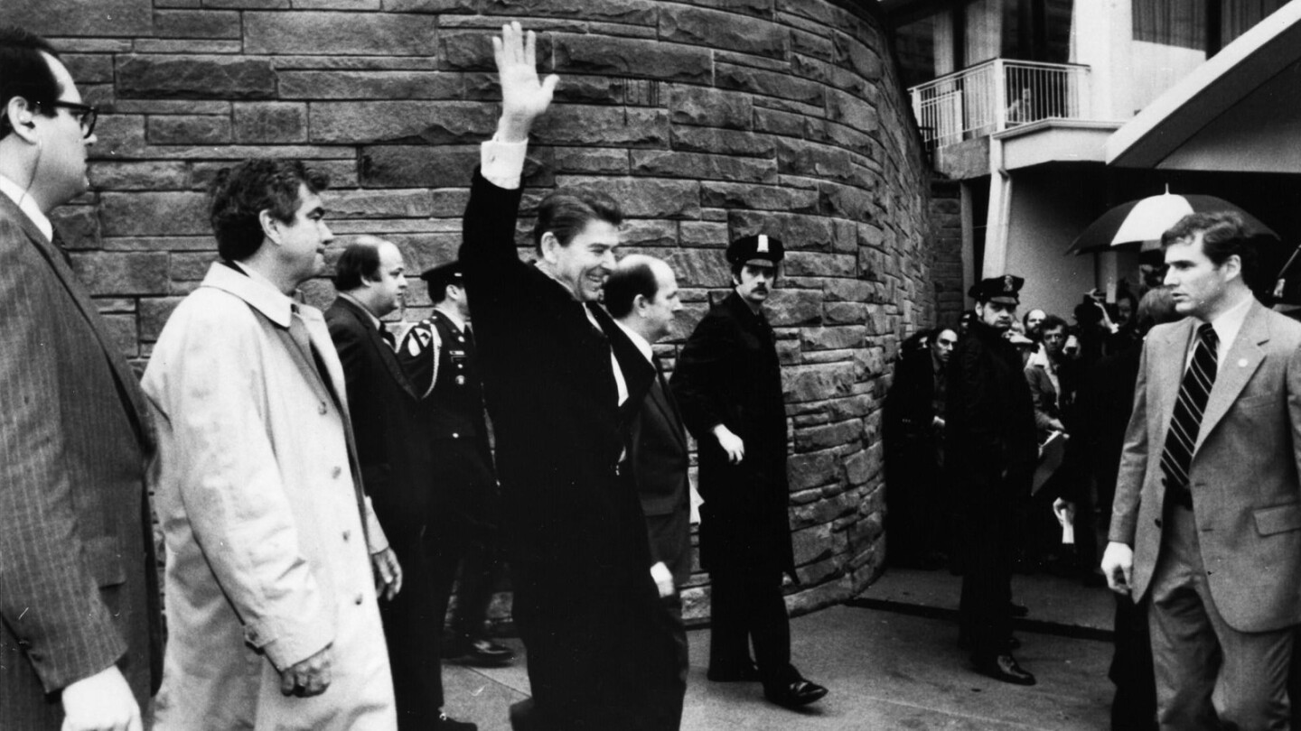 President Reagan waves just before he was shot outside a Washington hotel in 1981. Secret Service Agent Jerry Parr, left, shoved Reagan into the presidential limo immediately after the shooting.