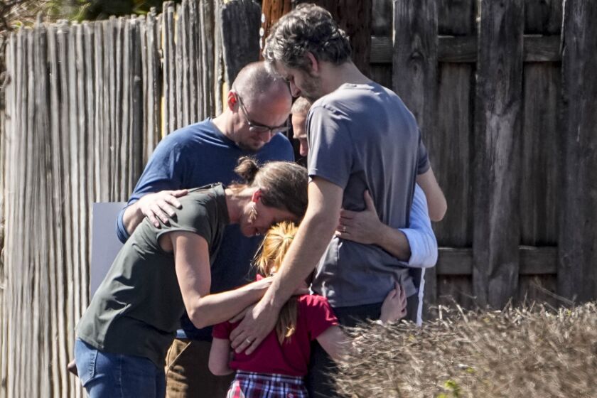 A group prays with a child outside the reunification center at the Woodmont Baptist church after a school shooting, Monday, March 27, 2023, in Nashville, Tenn. (AP Photo/John Bazemore)