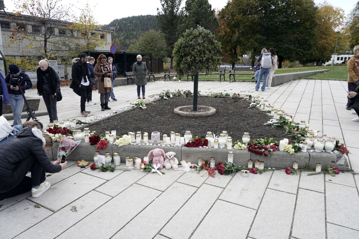 Flowers and candles are left after a man killed several people, in Kongsberg, Norway, Thursday, Oct. 14, 2021. Police in Norway are holding a 37-year-old man from Denmark suspected in a bow-and-arrow attack in a small town that killed five people and wounded two others. (Terje Pedersen/NTB via AP)