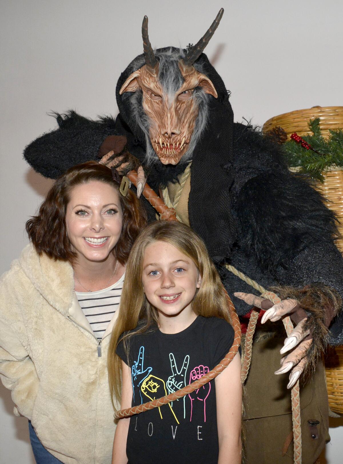 Rachel Buckman, left, was joined by her daughter, 8-year-old, Sophie, who attends Roosevelt Elementary School, to meet Krampus, portrayed by Bill Rude, at Dark Delicacies in Burbank.