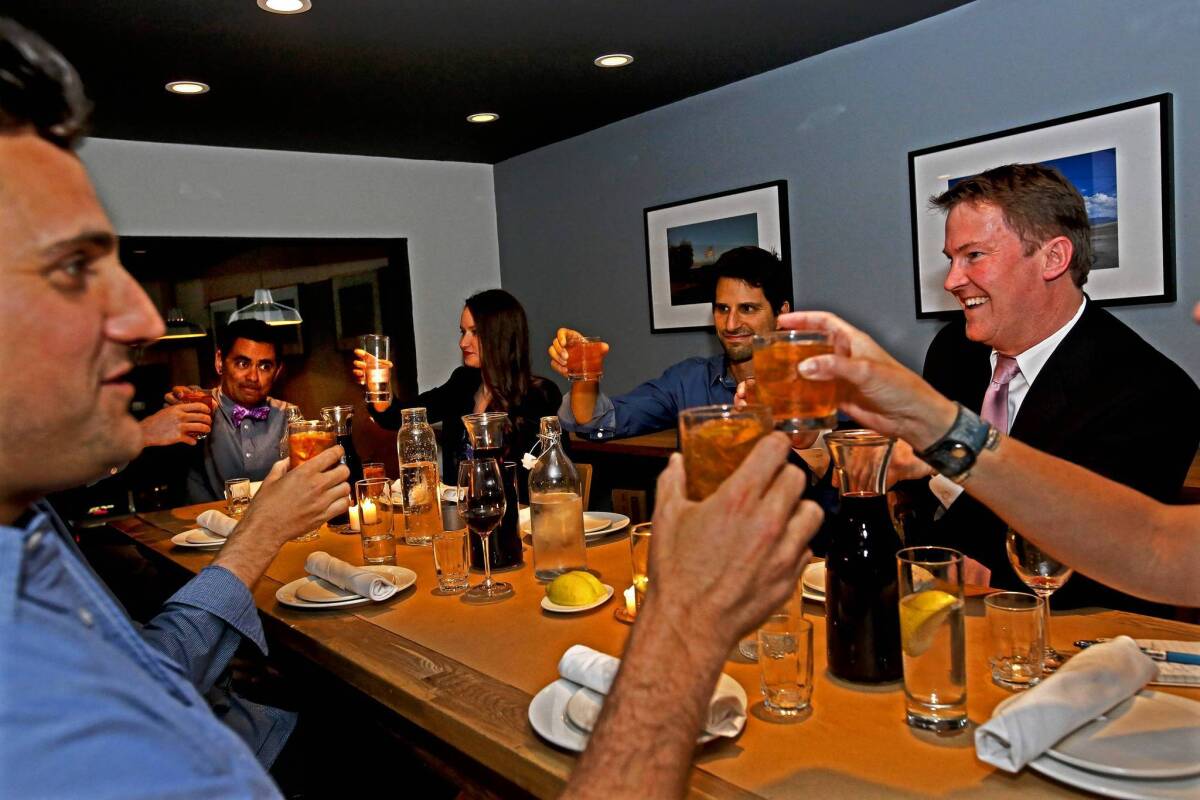 Participants toast Joseph Moller, left, Casey Alva, second from left, Jocelyn Webber, center, Mike Dow, second from right, and Kevin James, right, during a special monthly dinner party called Salon at Osteria La Buca.