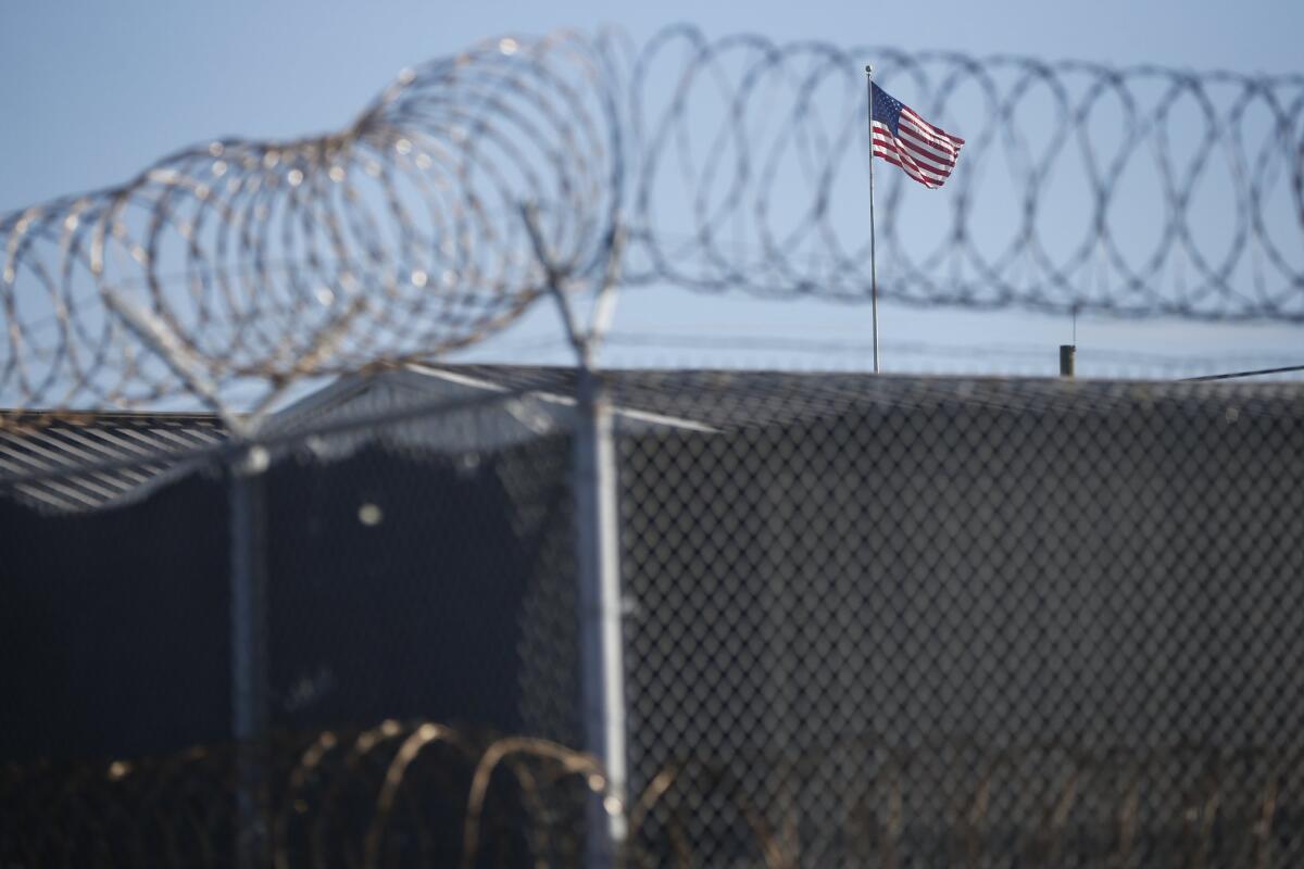 A U.S. flag flies above buildings used for military tribunals for suspected terrorist prisoners at the naval base at Guantanamo Bay, Cuba, on Nov. 19, 2013.