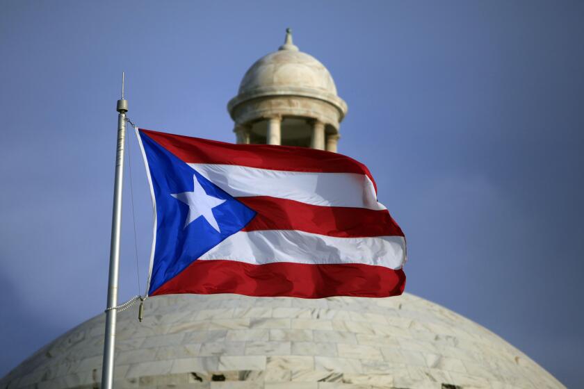 The Puerto Rican flag flies in front of Puerto Rico's Capitol in San Juan.