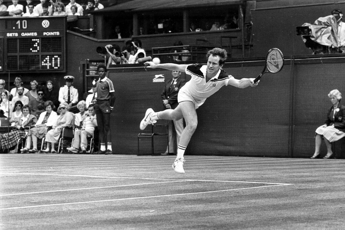 John McEnroe, the defending champion, flies through the air in an attempt to reach a shot.