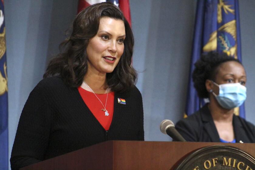In this Friday, June 5, 2020 photo provided by the Michigan Office of the Governor, Michigan Gov. Gretchen Whitmer speaks in Lansing, Mich. Gov. Whitmer said Friday that barbershops and other personal-care businesses can reopen across Michigan on June 15, while those businesses and places like gyms and movie theaters that were shut down for months to curb the coronavirus can restart in northern Michigan next week. (Michigan Office of the Governor via AP, Pool)