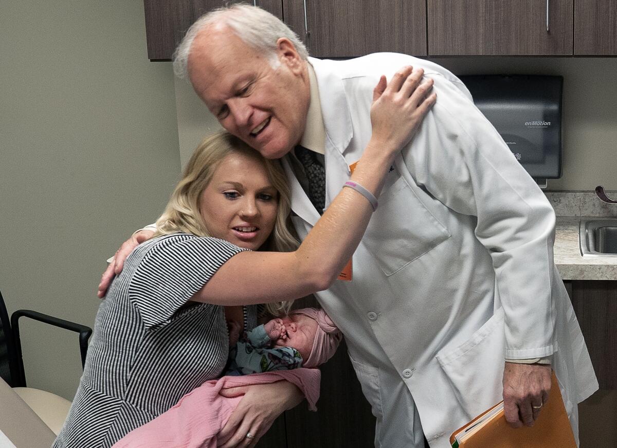 Dr. Craig Towers greets Kayla Daniell, with baby daughter Aurora