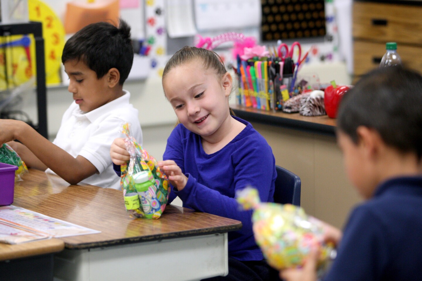 First-grader Michelle Solorzano looks at the Easter goody bag she and other students received from Glendale police officers, at Cerritos Elementary School, in Glendale on Tuesday, March 15, 2016. The Cops for Kids program brings local students goody bags at certain times of the year. Students at the school received goody bags which included Glendale Police safety items and some plastic easter eggs with candy.