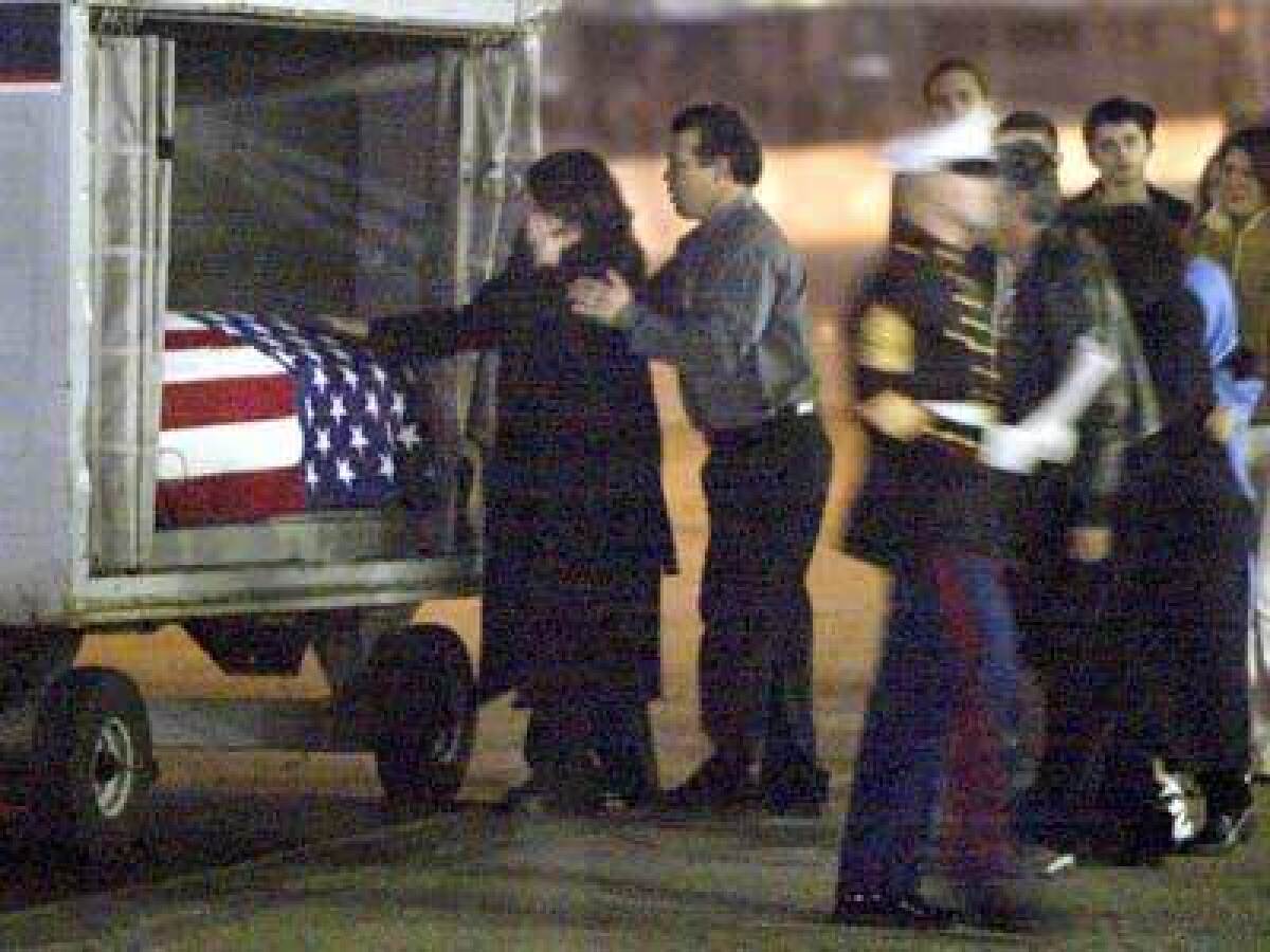'NO! NO!': Marina Beyer of Alamo, Calif., breaks down as the coffin of her son arrives at an airport cargo bay. "In my mind, he was still my little boy," she said.