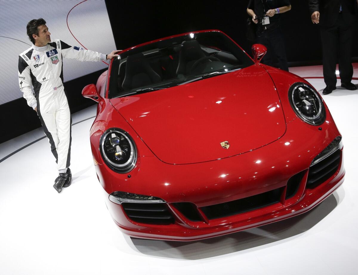 Actor Patrick Dempsey poses next to the 2015 Porsche 911 Carrera GTS during the Los Angeles Auto Show on Wednesday. Porsche North America said that Dempsey will race in the 24 Hours of Le Mans in 2015 in a Porsche 911 RSR.