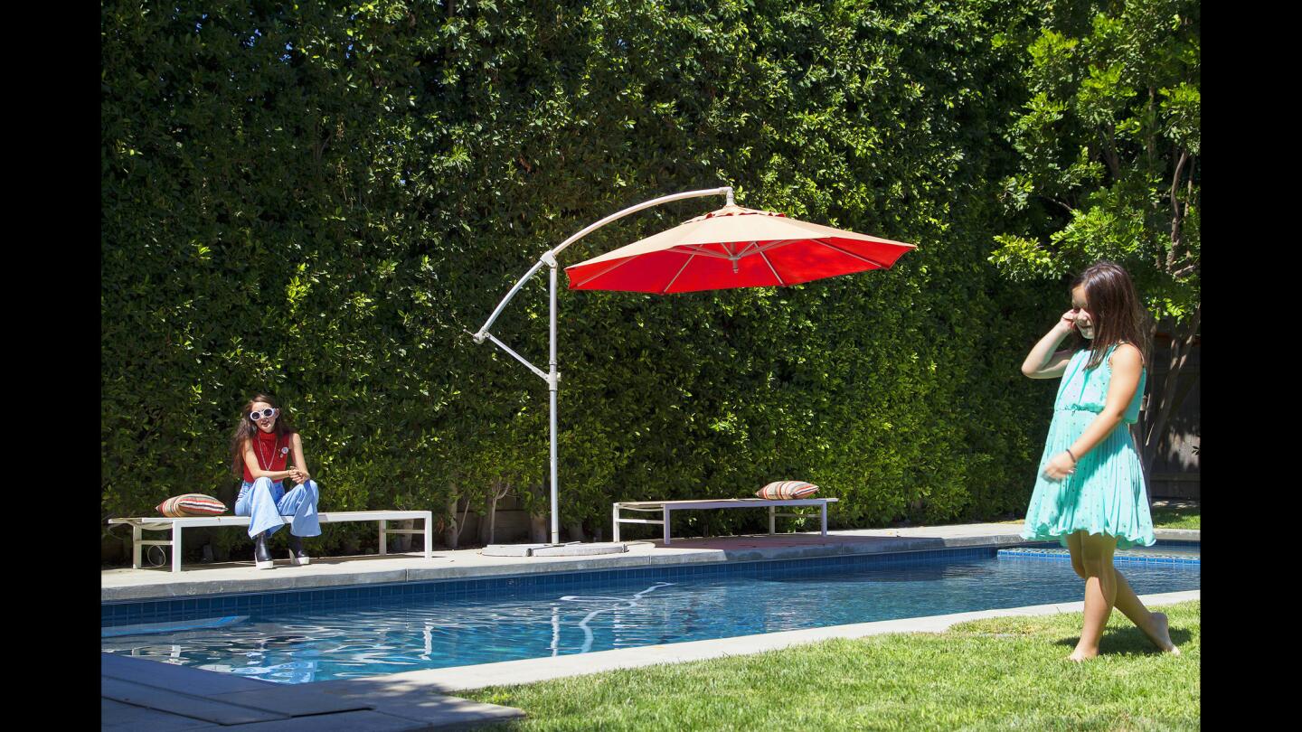 Skye Battles, 18, left, and Grey Arguelles, 6, in their Studio City backyard.