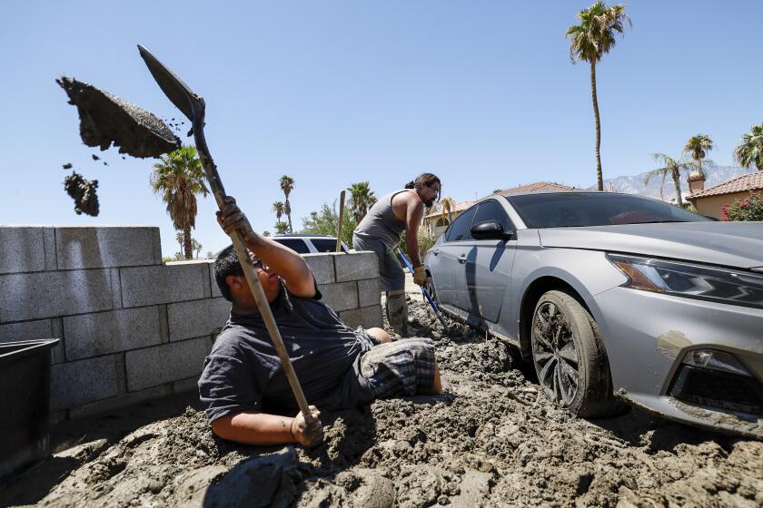 Cathedral City, CA, Wednesday, August 23, 2023 - Justin Duran helps dig out a car stuck in the mud as residents of Horizon Rd. Clean up days after Tropical Storm Hilary flooded their community. (Robert Gauthier/Los Angeles Times)