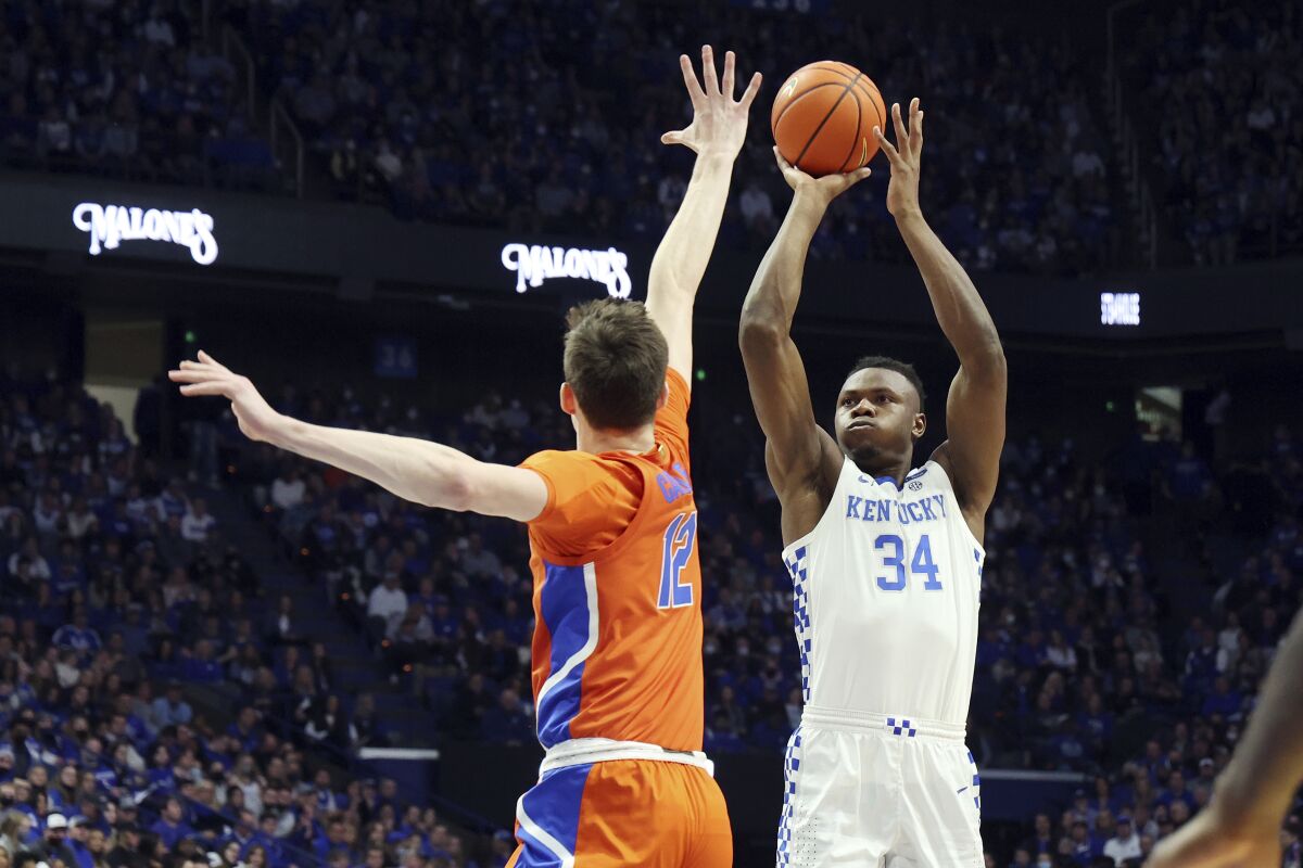 Kentucky's Oscar Tshiebwe (34) shoots while defended by Florida's Colin Castleton (12) during the first half of an NCAA college basketball game in Lexington, Ky., Saturday, Feb. 12, 2022. (AP Photo/James Crisp)