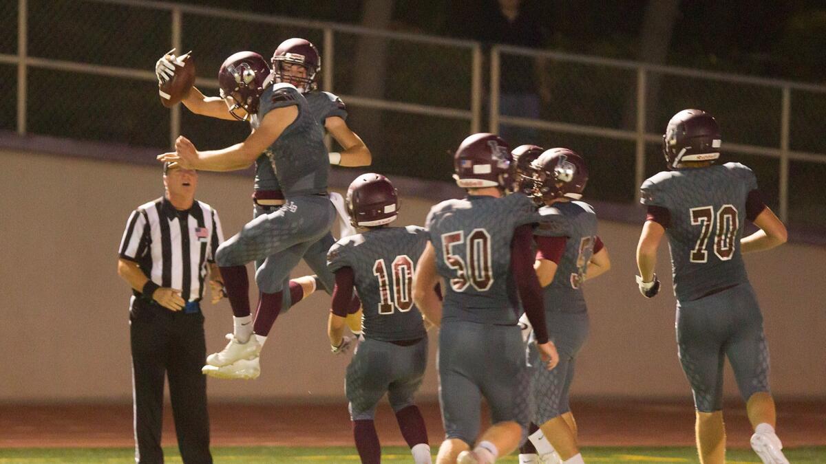 Laguna Beach's Sean Nolan celebrates a touchdown with teammates in the first half Friday against Orange. Nolan finished with 119 receiving yards and two touchdowns, but it wasn't enough as the Breakers lost 26-19.