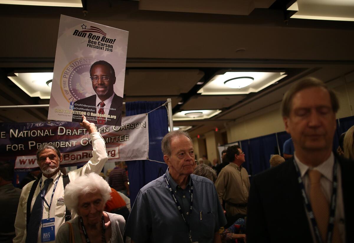 An attendee holds a sign in support of a presidential run by retired neurosurgeon and columnist Ben Carson during the 2014 Republican Leadership Conference in New Orleans, La.