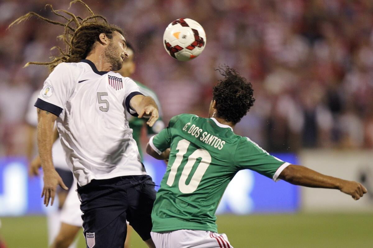 The United States' Kyle Beckerman, left, heads the ball away from Mexico's Giovani dos Santos during the first half of Tuesday's World Cup qualifying soccer match.