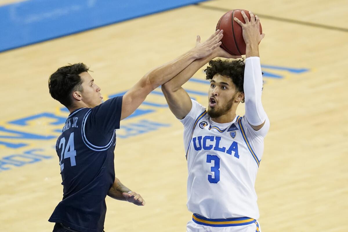 UCLA guard Johnny Juzang, right, is fouled by San Diego guard Chris Herren Jr. during the second half.