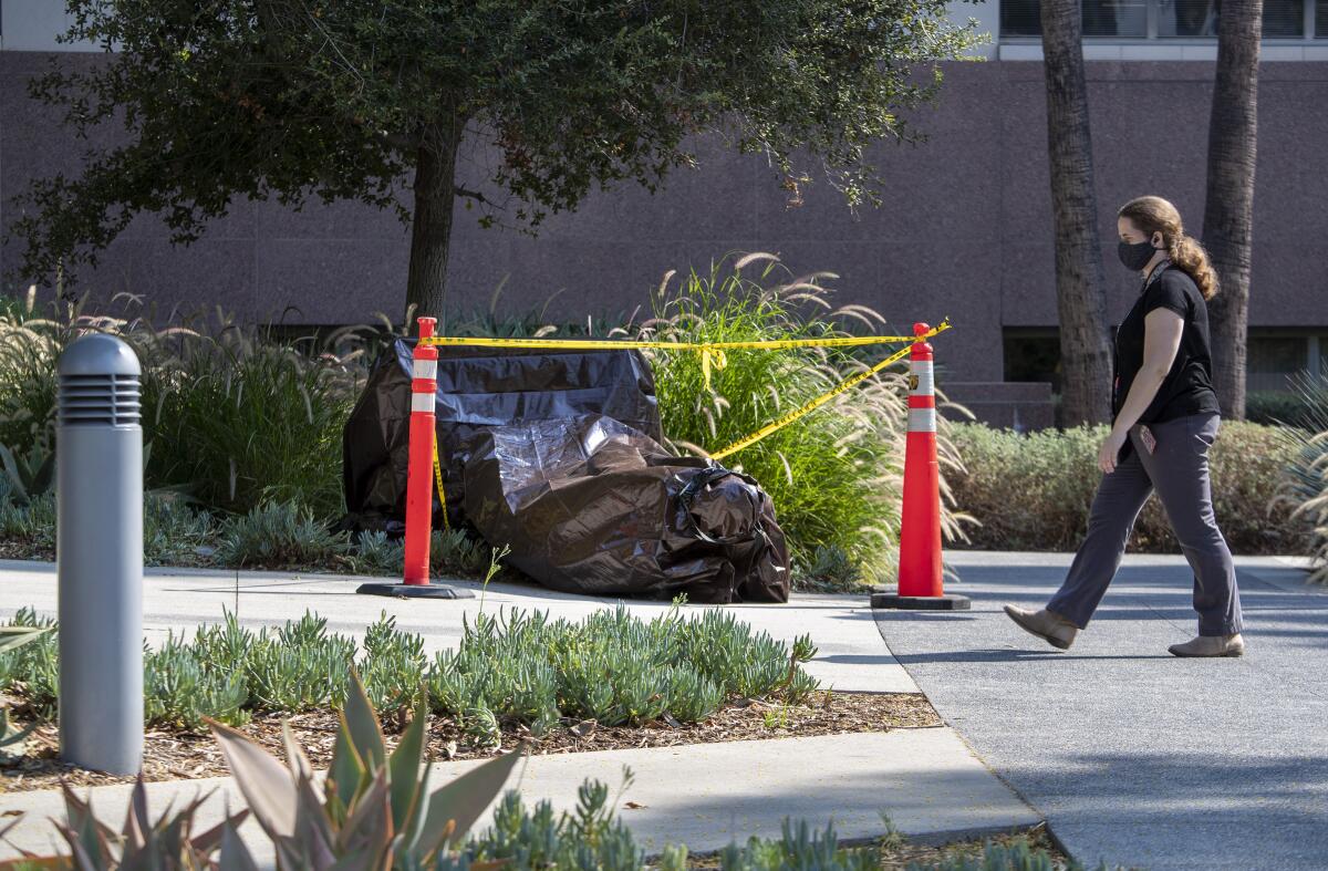 A vandalized statue is wrapped in a brown tarp in Grand Park in downtown Los Angeles.