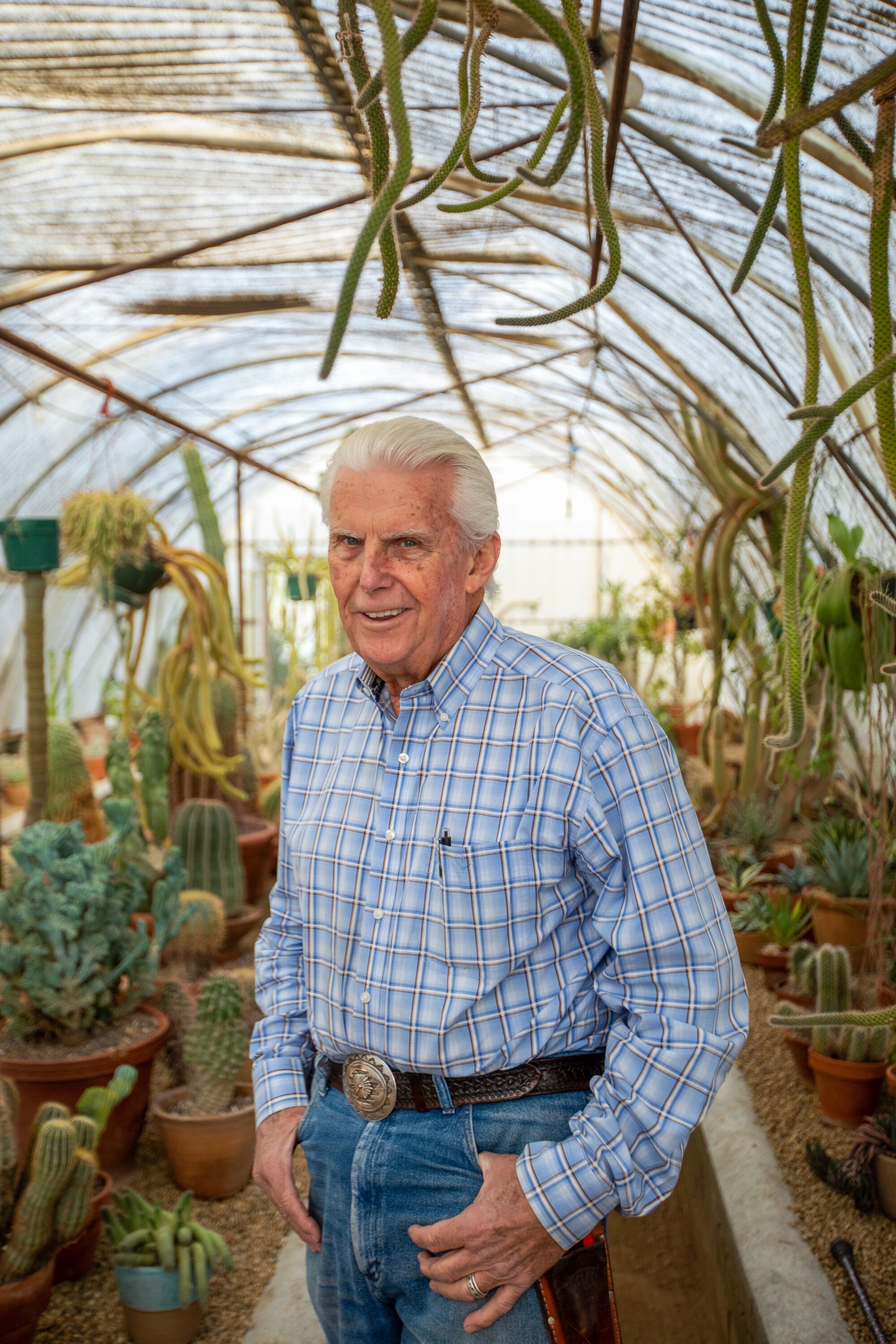 Clark Moorten framed by rare exotic cactus in Moorten Botanical Garden's "cactarium."