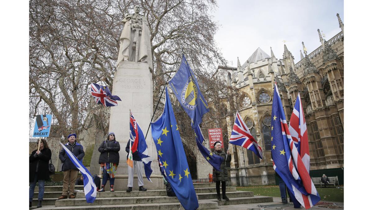 Anti-Brexit demonstrators wave flags outside the houses of Parliament in London.